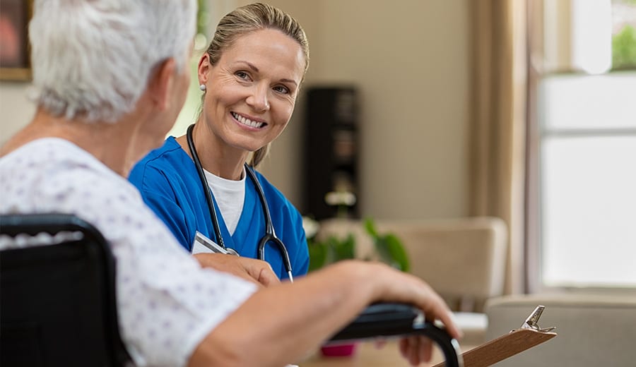En sjuksköterska som pratar med en äldre patient