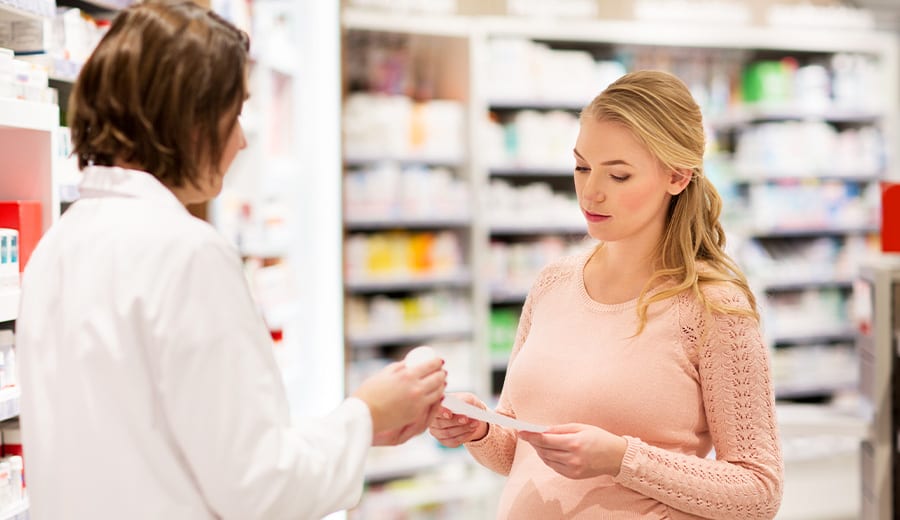 En kvinna i ett apotek som hämtar ut sin medicin