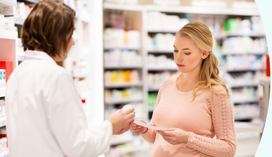 Receptförskrivning - Rätt medicin i tid En kvinna i ett apotek som hämtar ut sin medicin